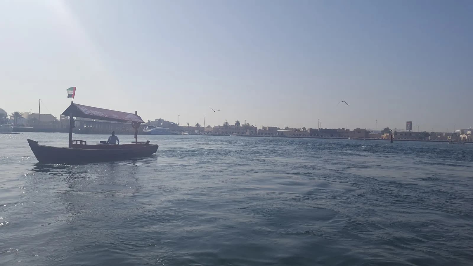 Tradycyjna łódź abra przepływająca przez zatokę Dubai Creek